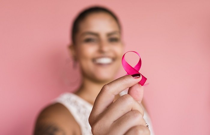 mulher com laço da campanha outubro rosa