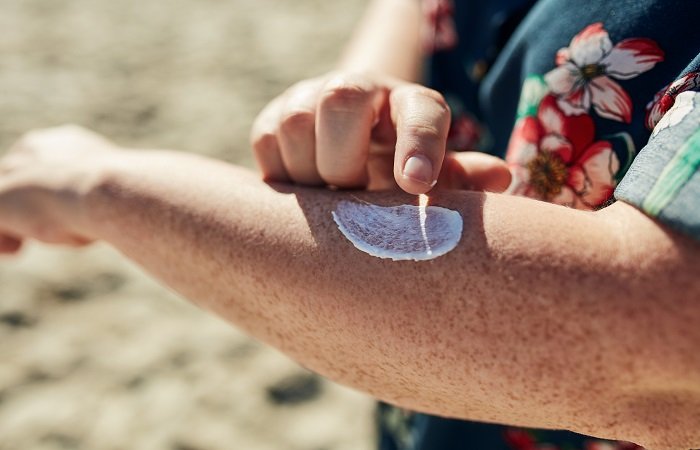 pessoa aplicando protetor solar para prevenir manchas de pele no verão