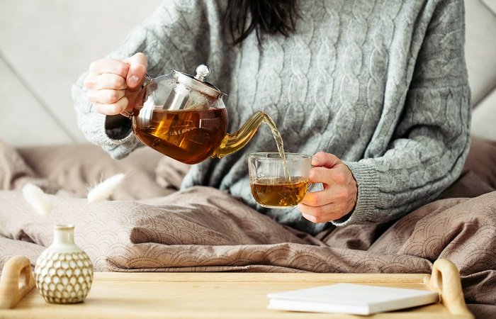 mulher tomando chá para substituir o café